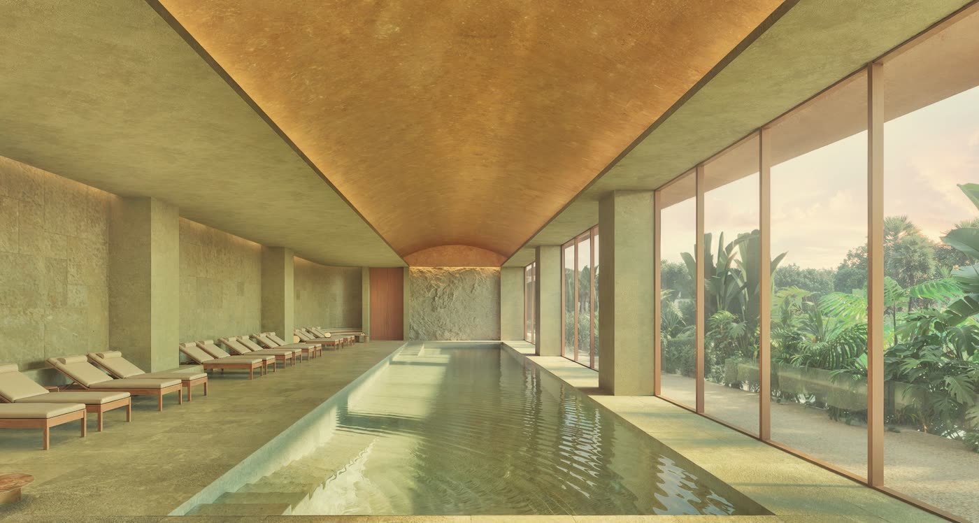 A long indoor lap pool with loungers and a glass wall onto the garden.