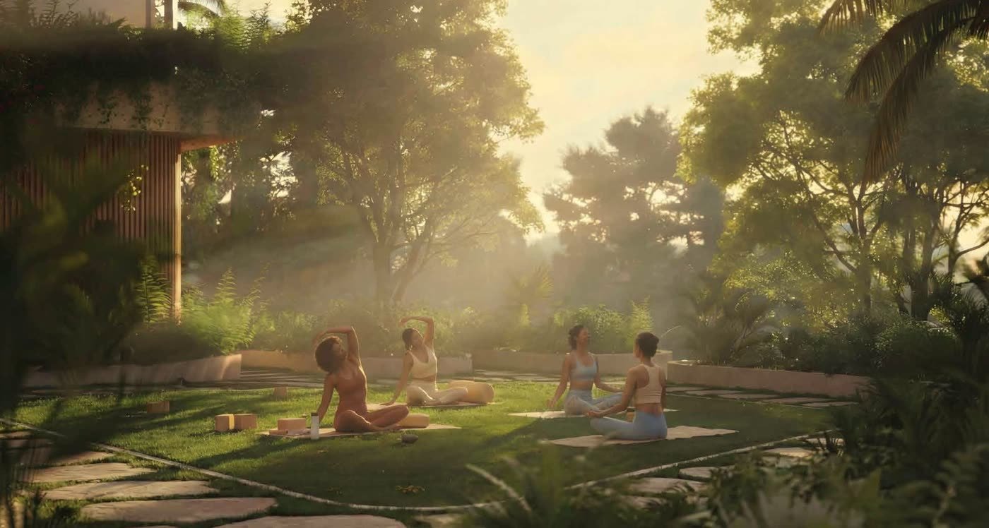 Four residents on yoga mats on a lawn under trees at sunrise.